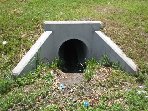 A discharge drain from a detention pond into a retention pond. 