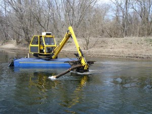 Another method of dredging involving heavy equipment on a barge. It's better than the first method but can still damage the environment and pond liners. Plus it's time consuming, awkward and costly.